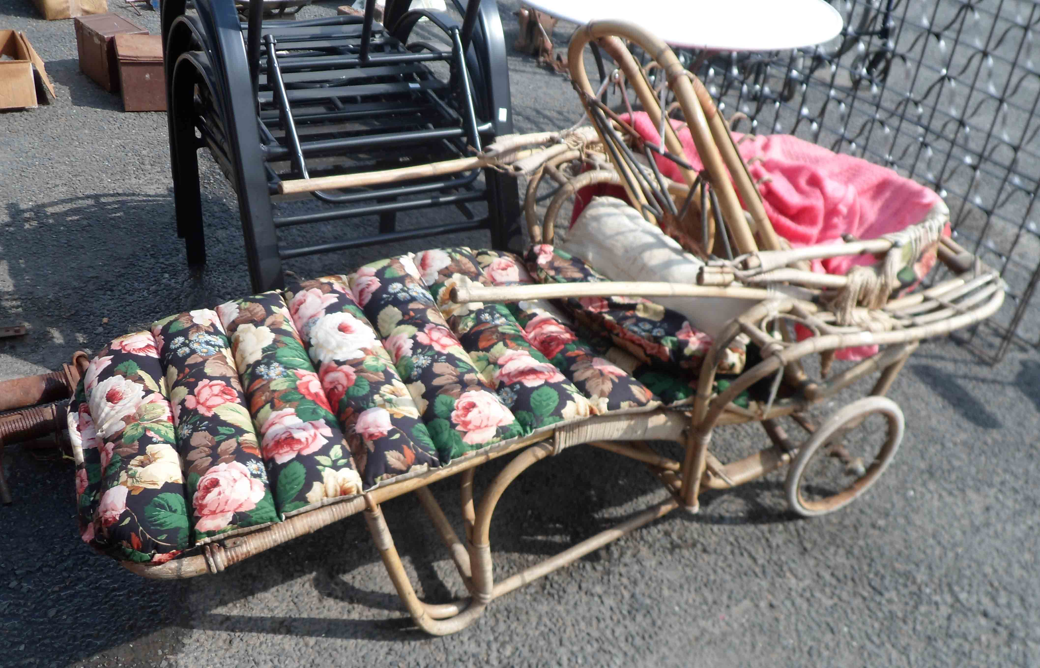 A vintage bamboo sun lounger with sprung frame, spoked wheels and detachable hood - with later re-