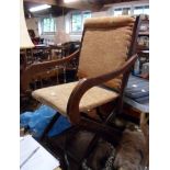 A late Victorian stained wood framed folding elbow chair with upholstered back and seat