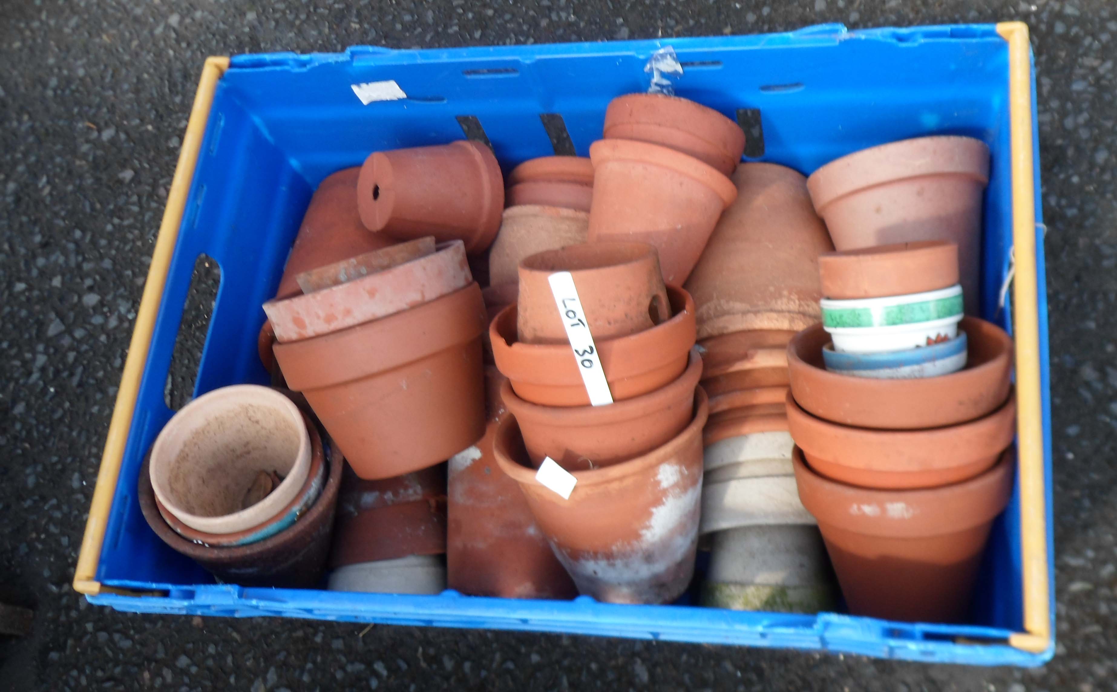 A crate containing a large quantity of terracotta garden pots