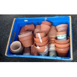 A crate containing a large quantity of terracotta garden pots