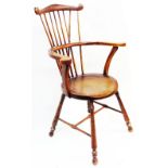 A 19th Century comb back Windsor elbow chair with solid moulded seat, set on turned supports