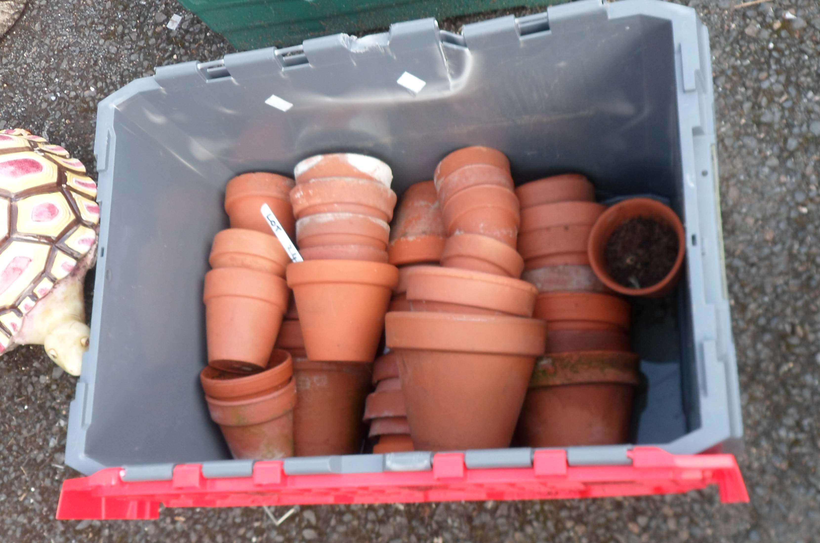 A crate containing a large quantity of terracotta garden pots