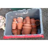 A crate containing a large quantity of terracotta garden pots