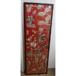 A framed 20th Century Chinese embroidery panel with figures, fence and flowers on red ground - 1.25m