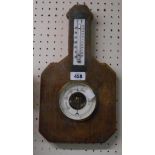 A vintage wall barometer with thermometer scale and visible aneroid works, set on a rustic wooden