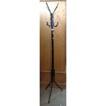A modern black painted metal freestanding hat and coat stand