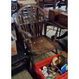 An old wheelback Windsor elbow chair with moulded solid elm seat, set on turned supports