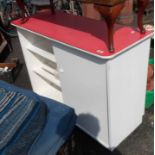 A vintage kitchen unit with red Formica top and sliding cupboard doors