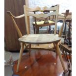 A vintage Ercol Model 493 light elm elbow chair with shaped double back rail and moulded solid seat,