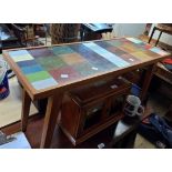 An 87cm retro stained wood coffee table with inset multi-coloured lino tiles to top, set on square