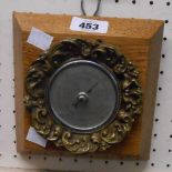 A vintage Smiths decorative cast brass mounted aneroid wall barometer, set on a heavy wooden panel