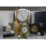 A selection of small timepieces and alarm clocks, comprising four mechanical and a quartz