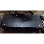A 1.06m old black painted tin lift-top transit trunk with latches and flanking drop handles