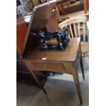 A vintage oak cased Singer sewing machine table with flip-top fold-out drawer - Singer 99K sewing
