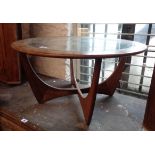 An 83cm diameter retro teak framed G-Plan Astra coffee table with inset glass top, set on moulded