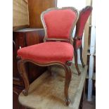 A set of four Victorian oak framed panel back dining chairs with red upholstery, set on cabriole