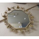 A vintage decorative painted wrought iron framed wall mirror with octagonal plate