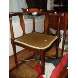 An Edwardian inlaid mahogany corner elbow chair with shaped back rail and upholstered seat, set on