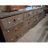 A 3.06m Victorian stained pine haberdashery unit with five flights of three deep drawers - one