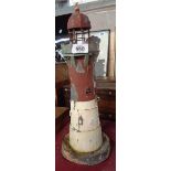 An old painted tin plate lighthouse model tea light holder