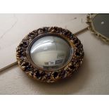 A vintage gilt plaster framed convex wall mirror with decorative pierced acanthus border