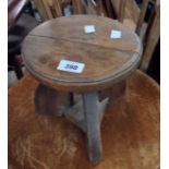 A small rustic stained milking style stool