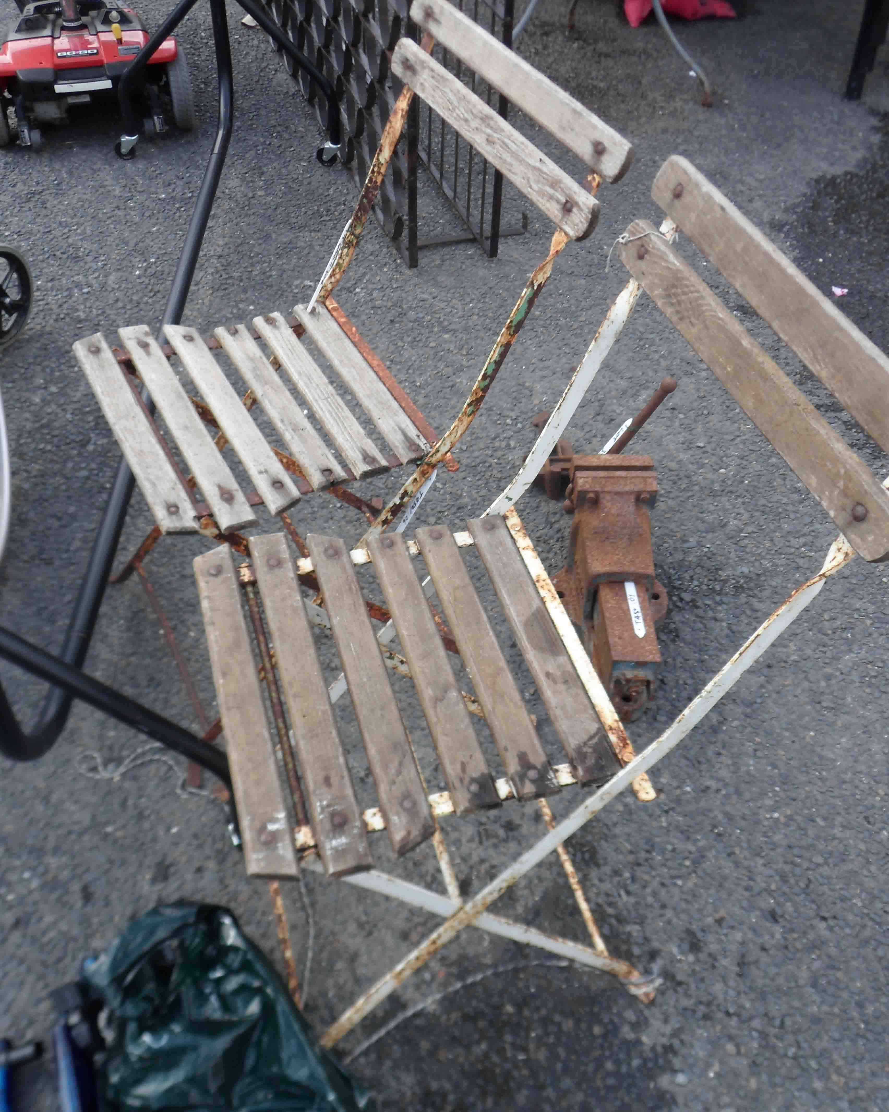 A pair of old wrought iron and wooden slatted garden chairs