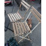 A pair of old wrought iron and wooden slatted garden chairs