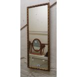 A modern gilt framed narrow oblong wall mirror with decorative border