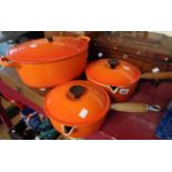 Two Le Creuset saucepans in the orange colourway and similar casserole - various condition