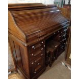 A 1.2m vintage oak roll-top desk with damaged tambour enclosing a part fitted interior over eight