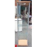 A 43cm modern wood effect and glazed display shelf unit with four shelves and interior