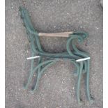 A pair of cast iron bench ends with wooden armrests and painted green finish