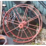 A pair of old cast iron cartwheels with later red painted finish