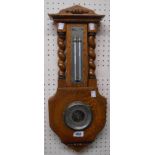 A vintage Eltex oak framed wall barometer with flanking barley twist pillars and visible aneroid