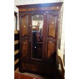 A 1.05m Edwardian stained walnut wardrobe with hanging space enclosed by a bevelled mirror panel