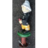 A vintage concrete garden fountain in the form of a fireman with painted finish, set on metal base