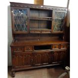 A 1.5m 20th Century stained oak two part dresser with pair of leaded glazed panel doors to top