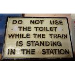 A modern painted cast iron Do Not Use the Toilet Whilst Train is Standing in the Station sign