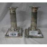 A pair of 12.5cm high silver Corinthian column candlesticks with beaded decoration to stepped bases,