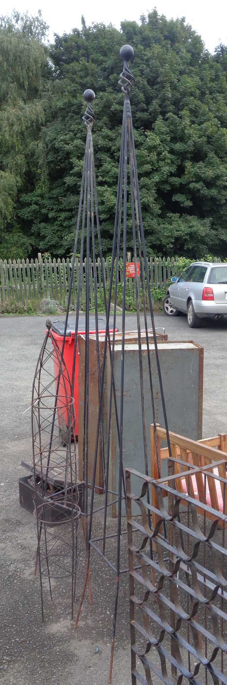 Two garden obelisks of wrought iron construction - sold with a smaller similar