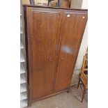 A 97cm Stag Minstrel wardrobe with hanging space, slides and shelves enclosed by a pair of moulded