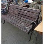 A garden bench with cast iron ends and slatted wooden seat