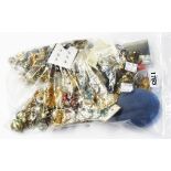 A bag containing a quantity of assorted costume jewellery brooches, ear-rings, etc.