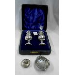 A cased pair of silver baluster pepperettes - sold with a silver shell pattern salt and bottle top -