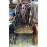 An antique elm wheelback Windsor country elbow chair with solid moulded seat, set on ring turned