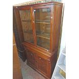 A 1.06m late Victorian pitch pine two part book cabinet with glazed top section over a blind