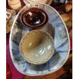 A small quantity of studio pottery including large painted dish and tenmoku glazed and other bowls