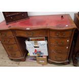 A 1.15m reproduction mahogany serpentine front kneehole writing desk with inset red leather