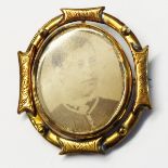 A late Victorian gilt metal swivel brooch with photographic portraits to front and back